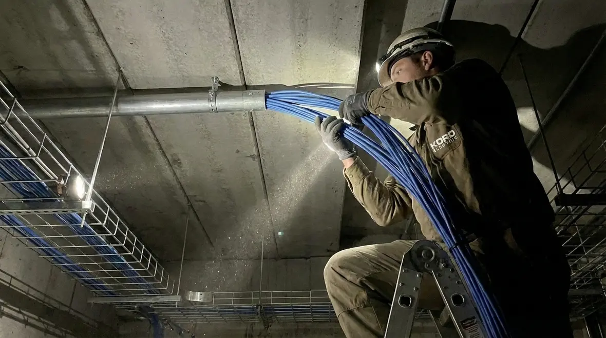 Technician installing security wiring in a commercial facility