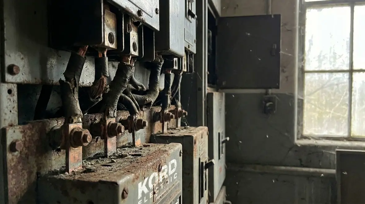 Technician performing electrical preventative maintenance scheduling on commercial switchgear