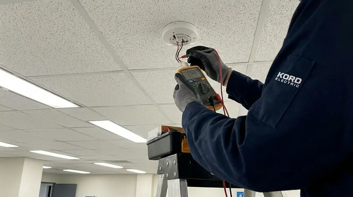 Technician checking supervised fire alarm circuits and device connections