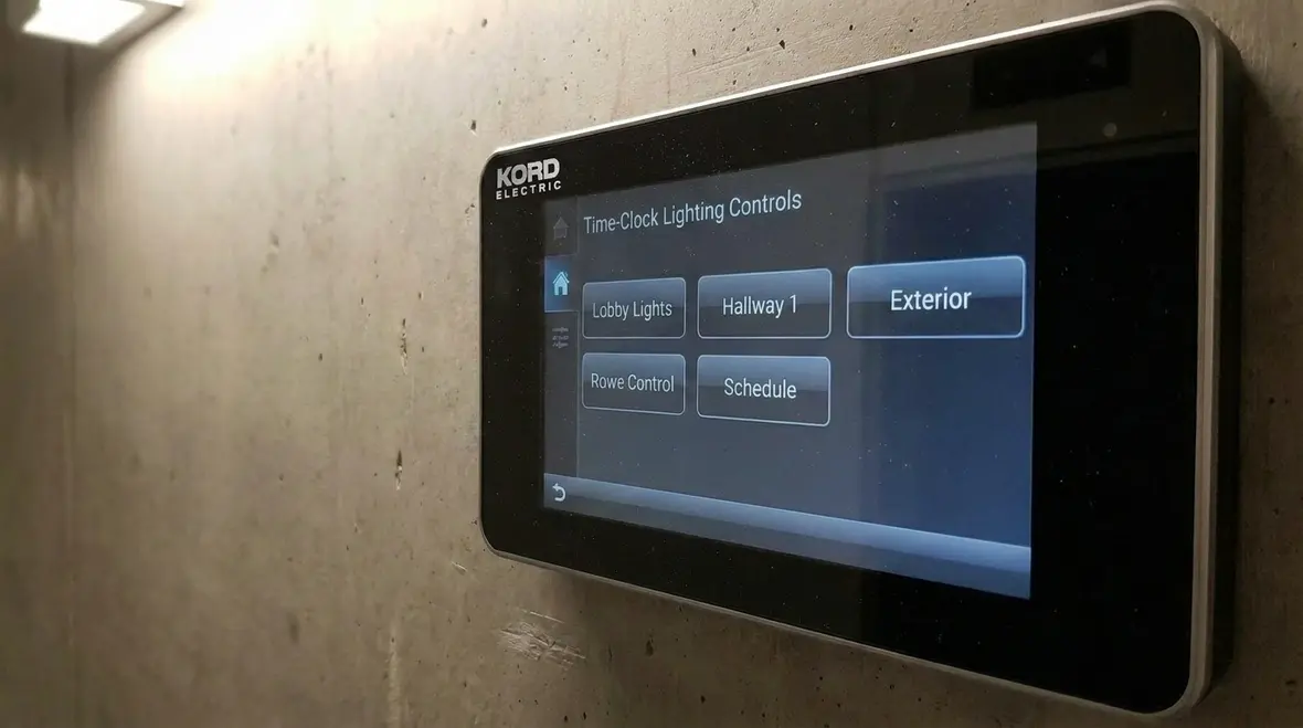 Technicians configuring automated lighting scheduling panel in commercial building