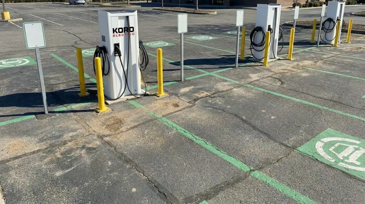 Project managers reviewing permits and utility plans for EV charging expansion
