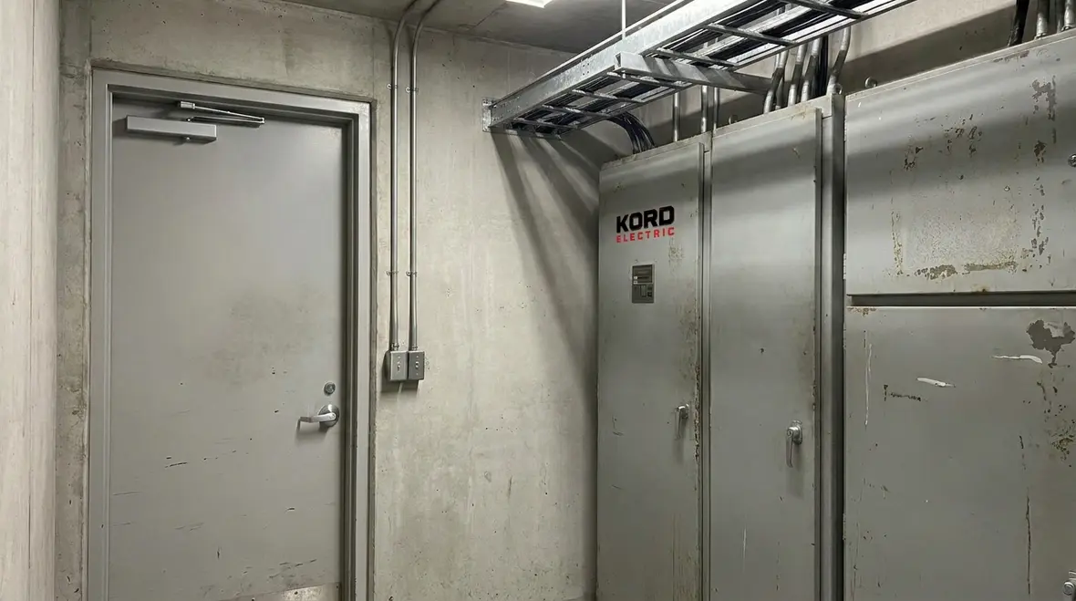 Electrician inspecting tall building electrical switchgear