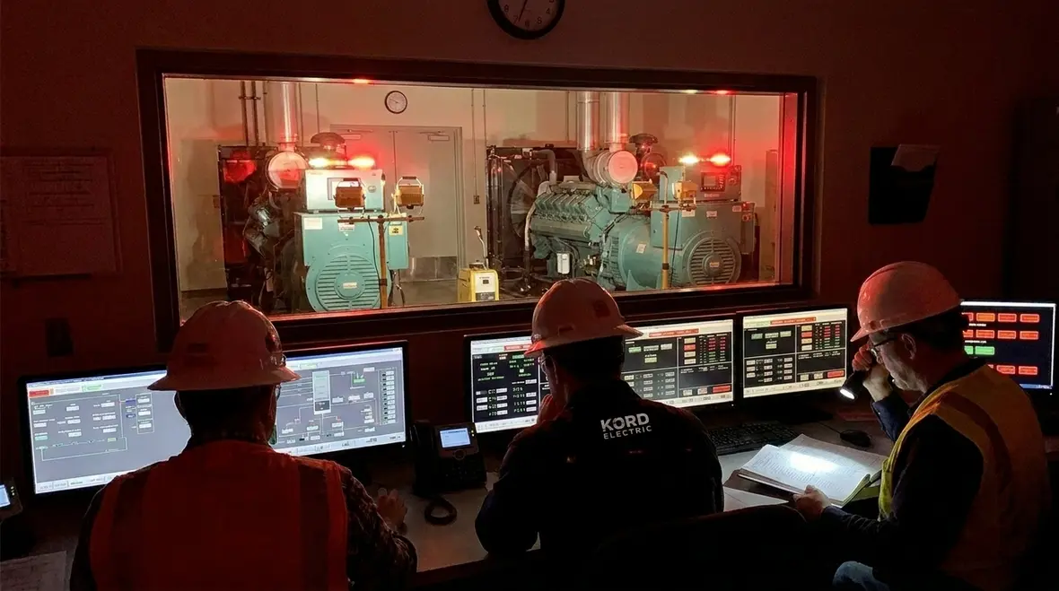 Technicians reviewing emergency power continuity planning diagrams for a commercial facility
