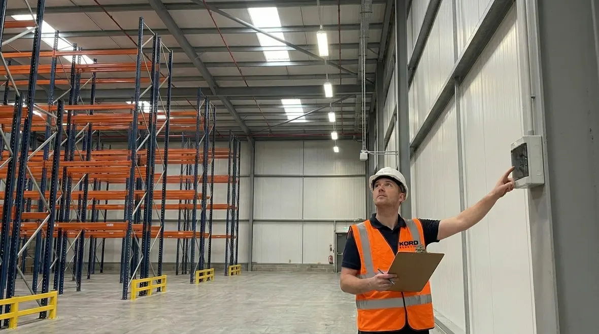 Technician reviewing a facility lighting maintenance strategy map for a commercial building