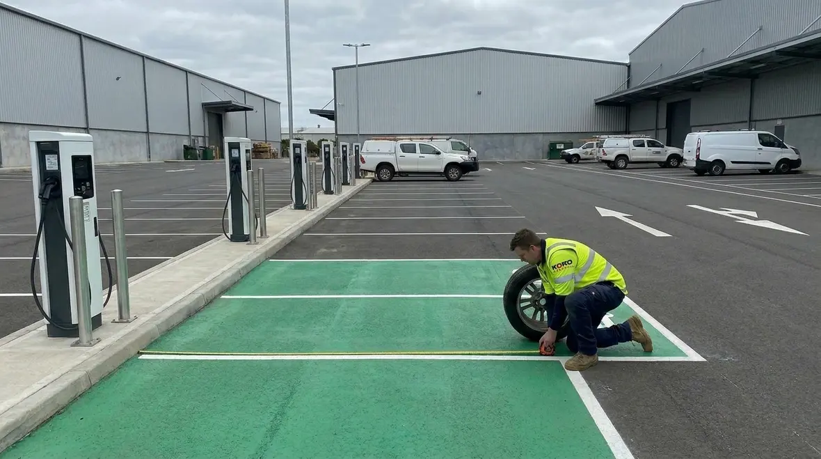 Technicians performing a Commercial EV charging site assessment in a commercial parking lot