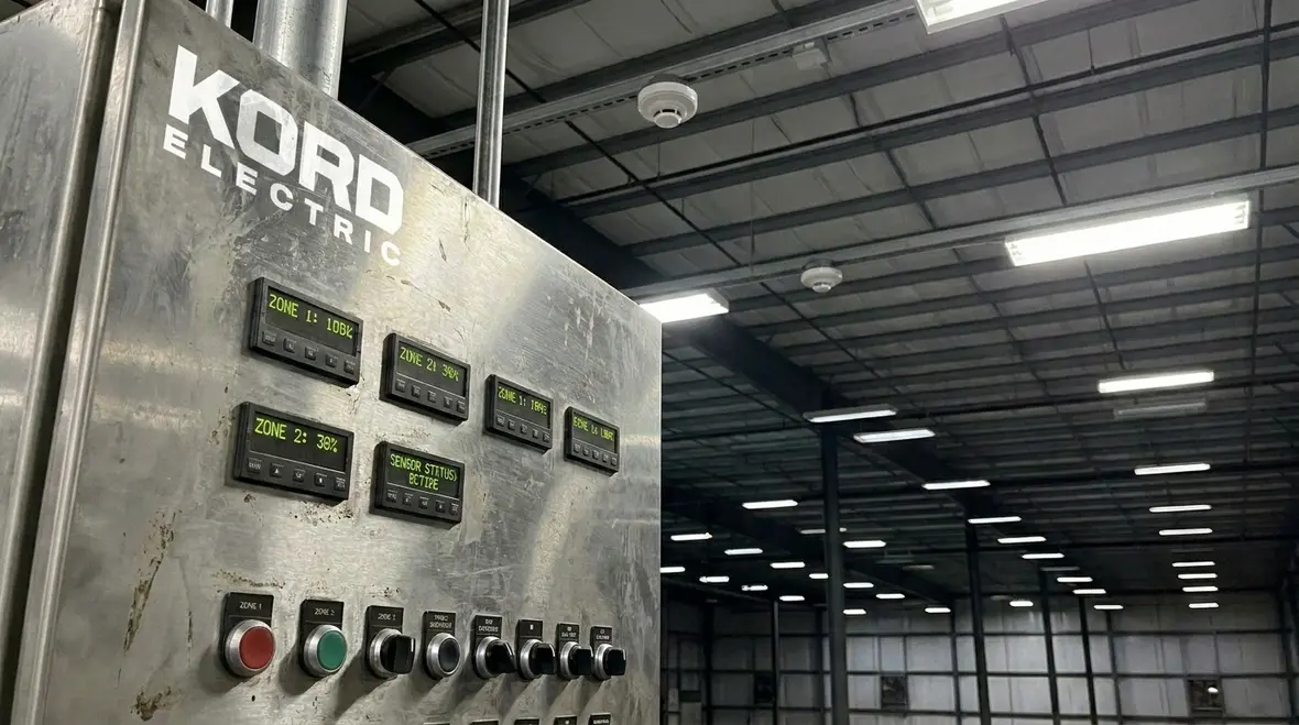 Technician assessing existing warehouse lighting for energy waste and safety