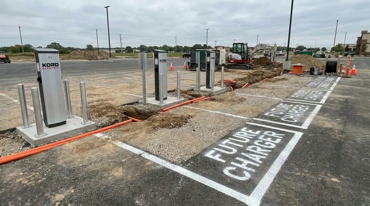 Technicians reviewing commercial EV infrastructure planning diagrams