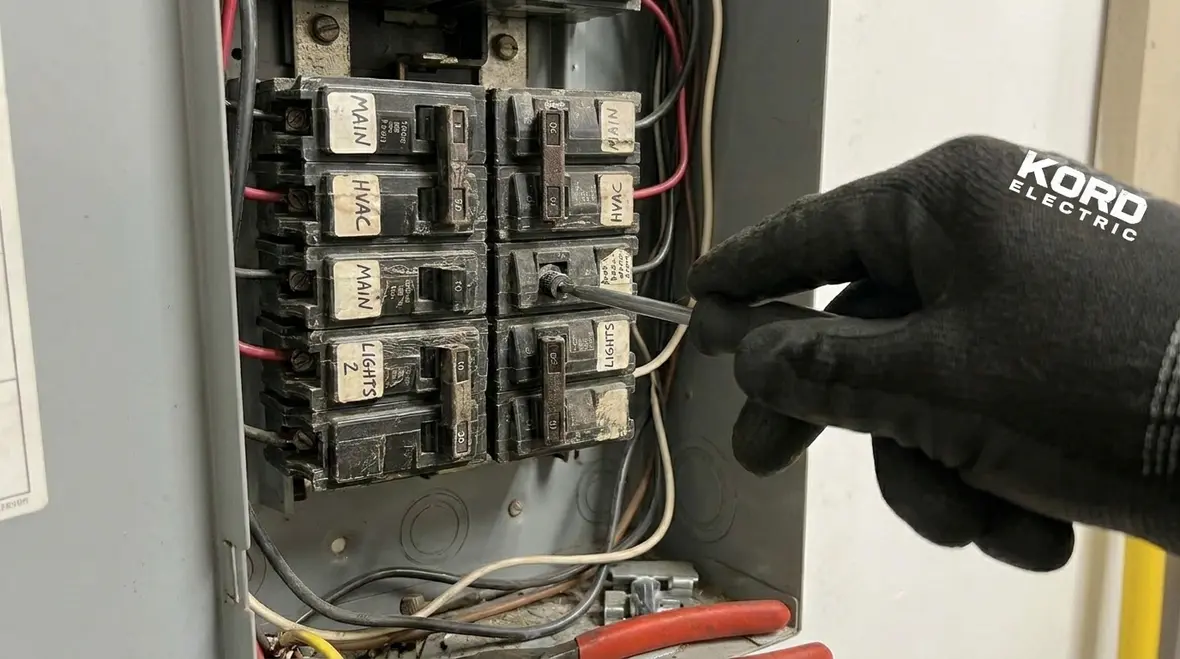 Technician performing electrical panel load analysis in a commercial facility