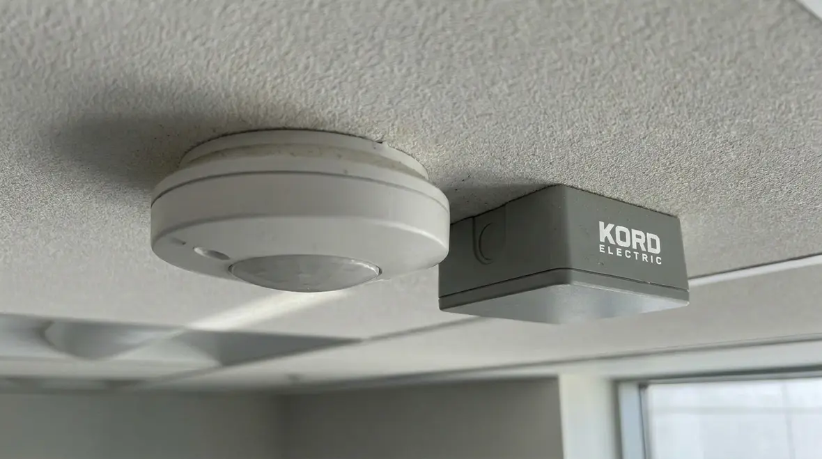 Technician assessing electrical stability for smart lighting ROI