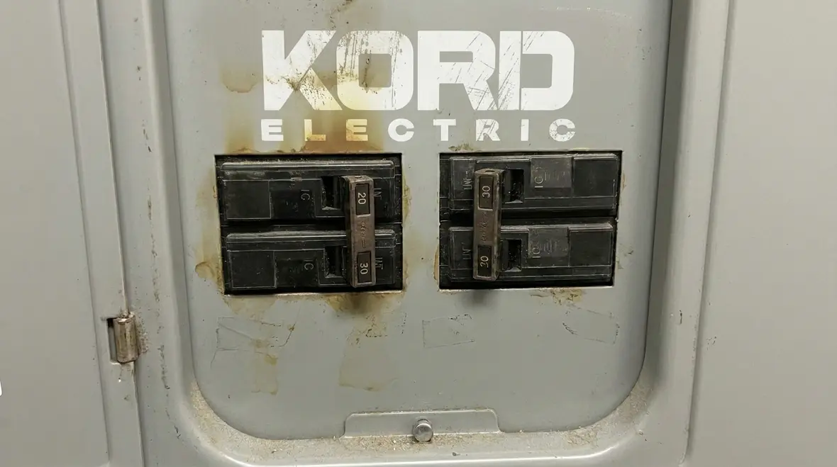 Technician inspecting a commercial electrical panel for early overload warning signs