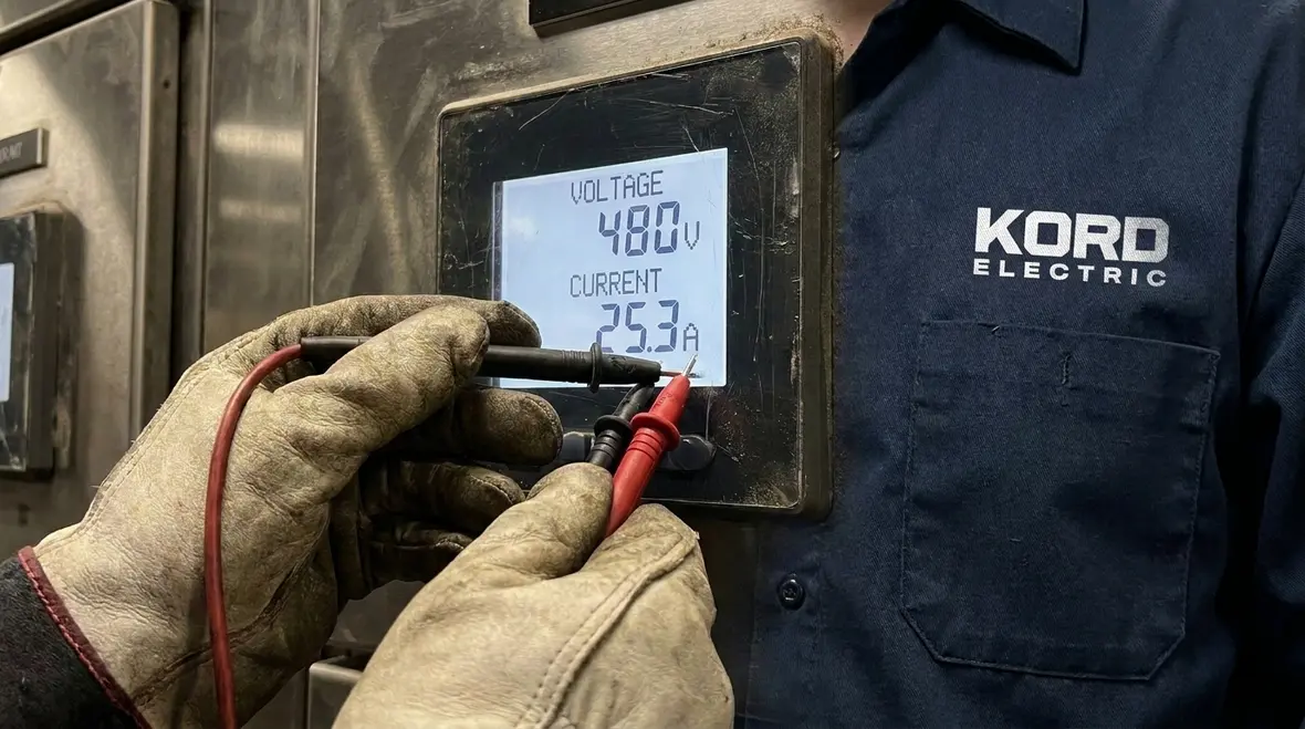 Technician monitoring voltage, current, and harmonics during utility load testing