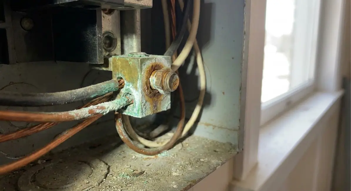 Technician inspecting a commercial electrical panel for overheating issues