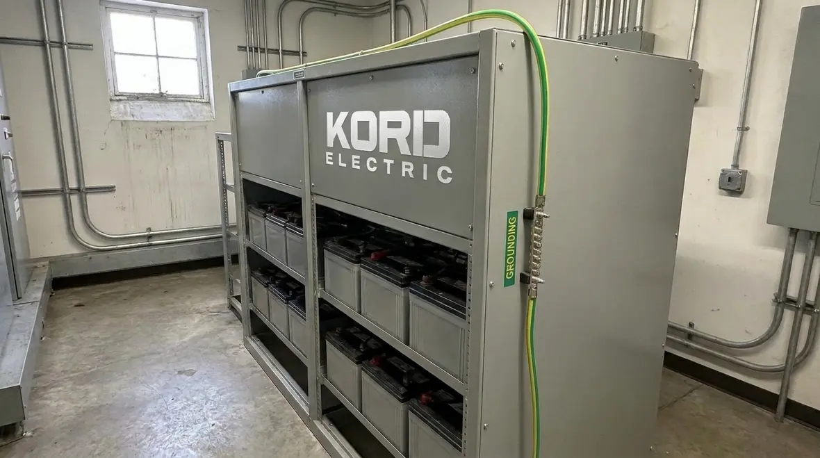 Technician reviewing an NEC DC grounding connection point in a commercial electrical room