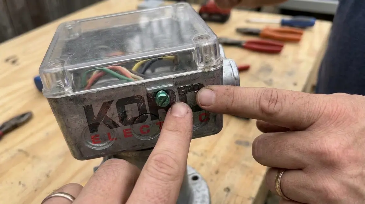 Close-up of NEC-compliant wiring device showing grounding terminal marking