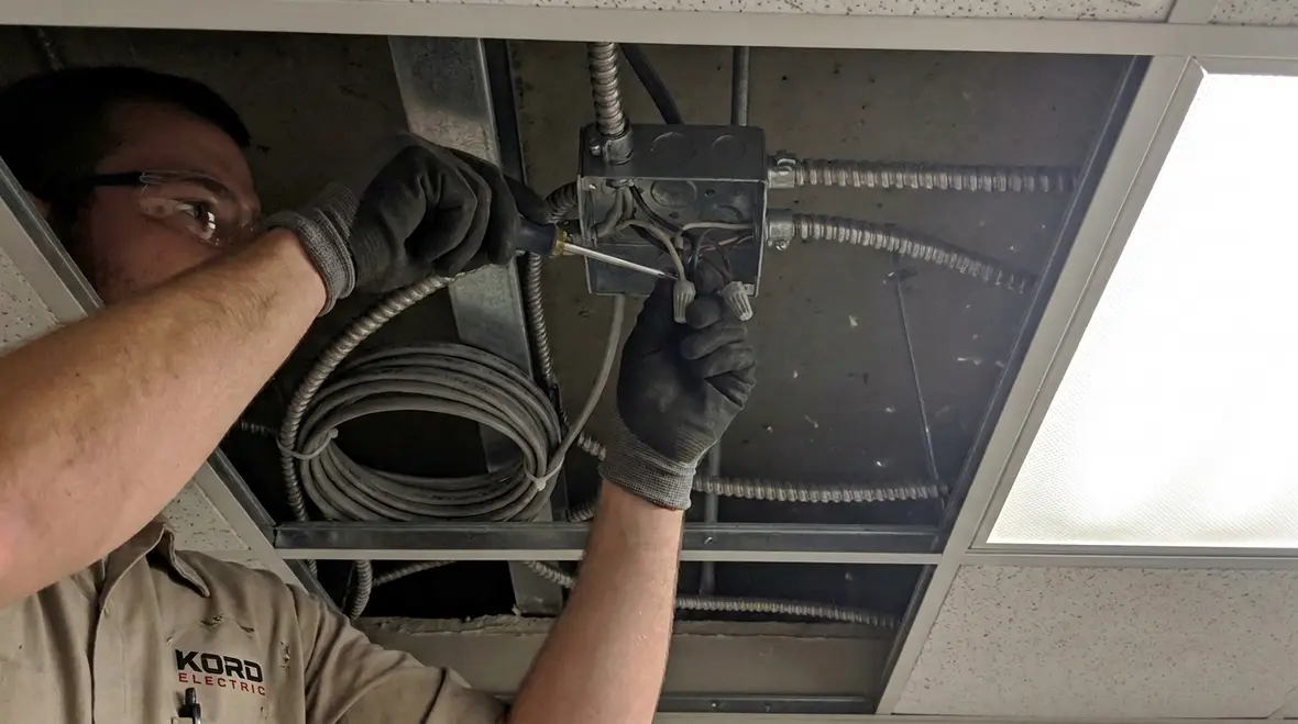 Technician reviewing NEC MC cable splices and taps under NFPA 70 Section 322.56