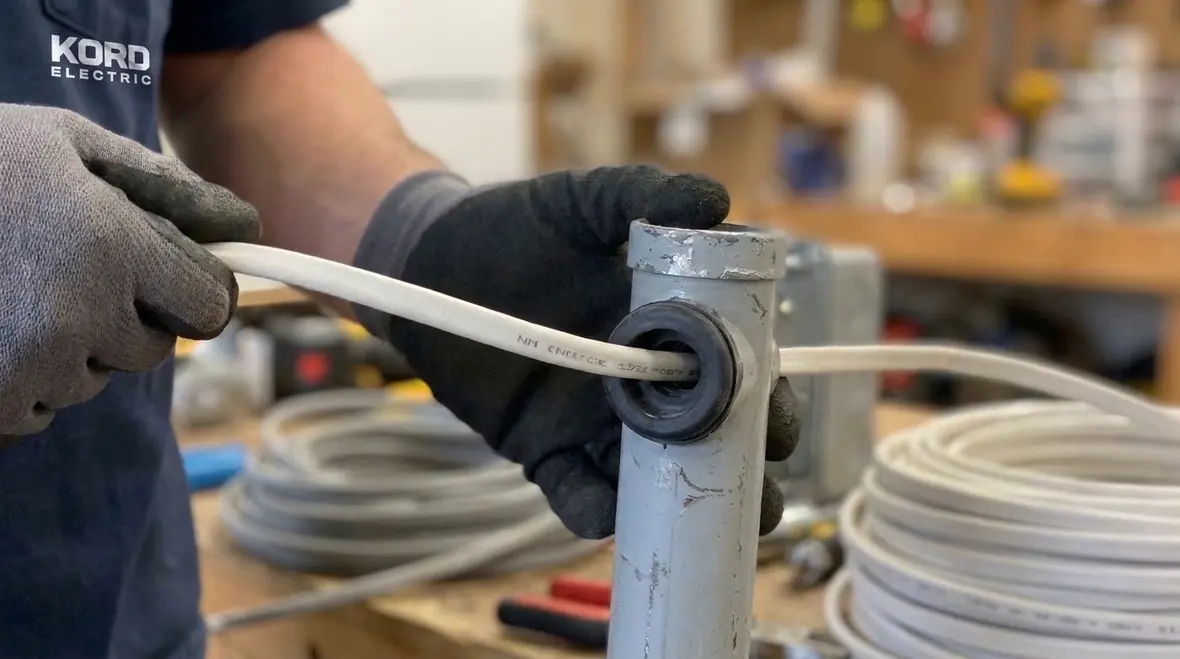 Technician reviewing NEC NM cable construction details before installation