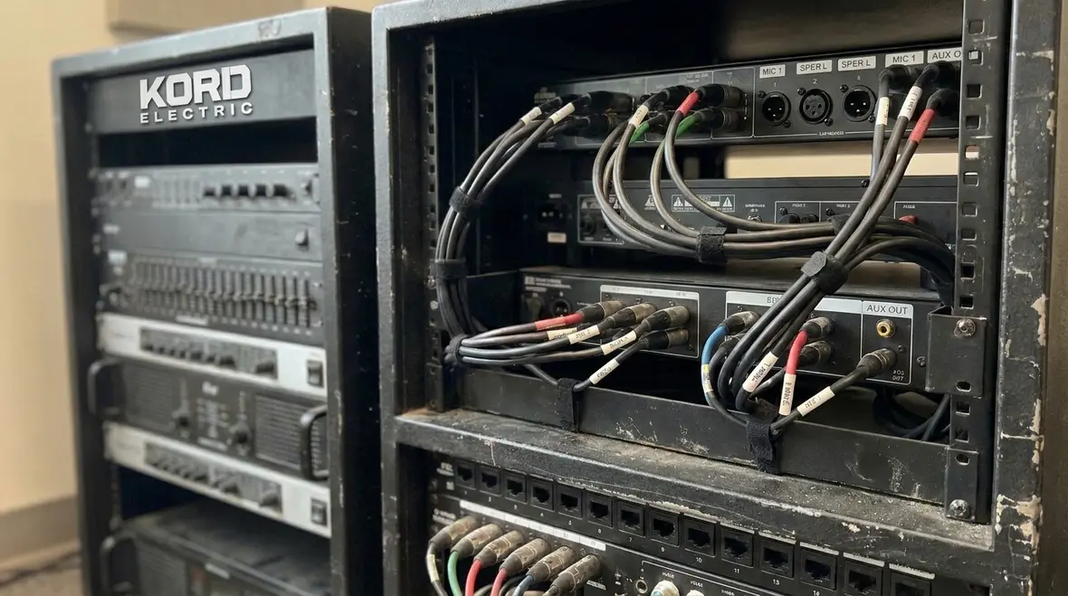 Technician reviewing NEC Section 640.22 audio equipment rack wiring in a commercial facility