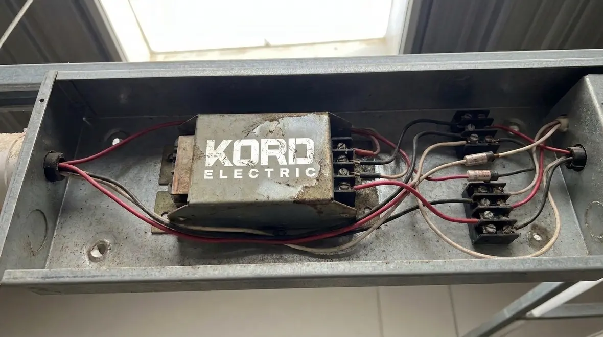 Close-up of discharge lighting ballast and wiring under inspection
