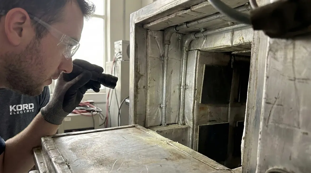Technician inspecting a dielectric heating enclosure for safety compliance