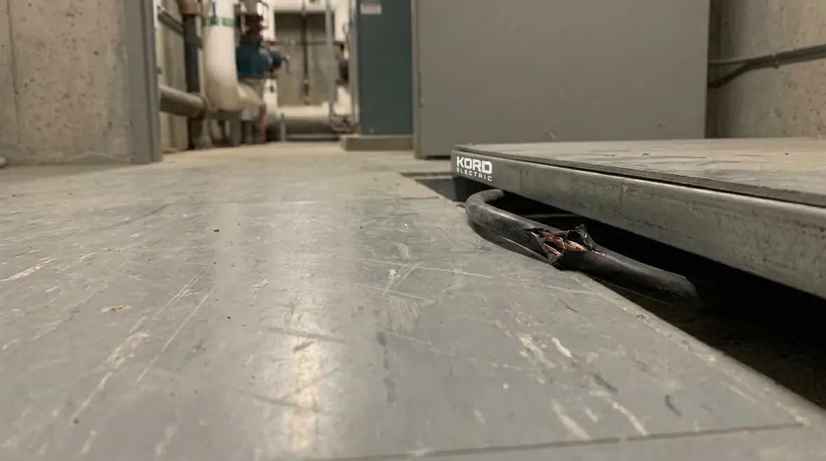 Technician correcting UF cable installation issues before floor coverings