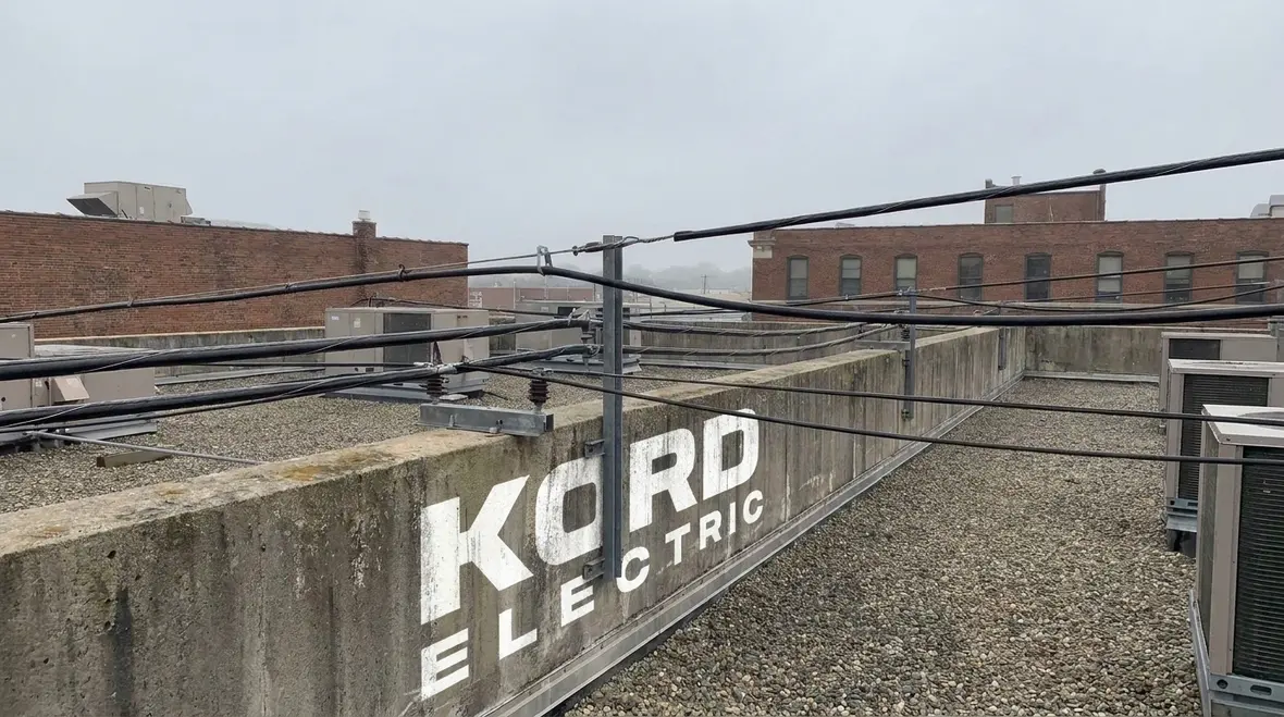 Overhead conductors maintaining NEC-compliant clearances above a commercial building rooftop