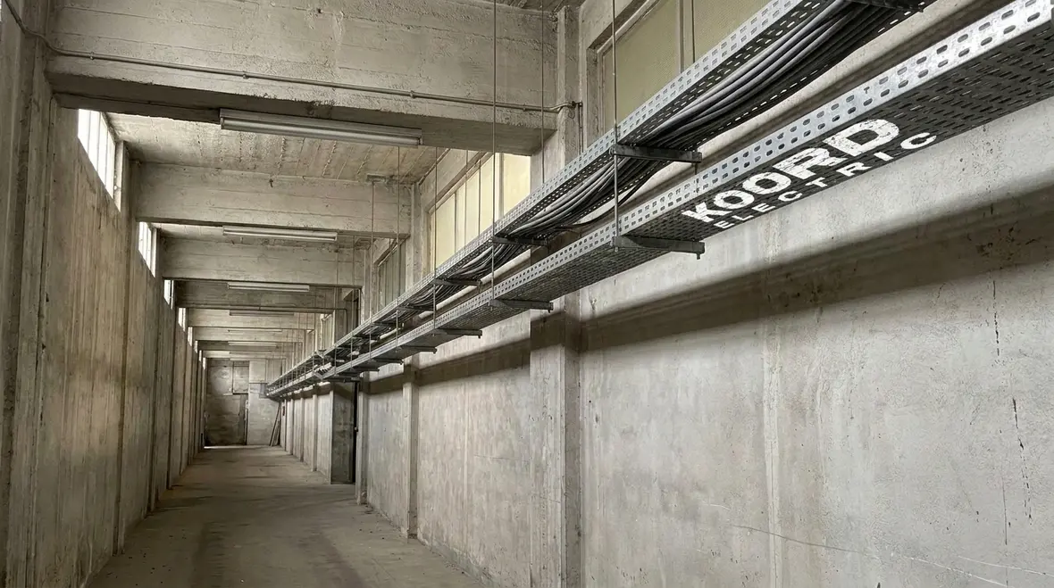 Exposed NM cable with added physical protection in an industrial corridor