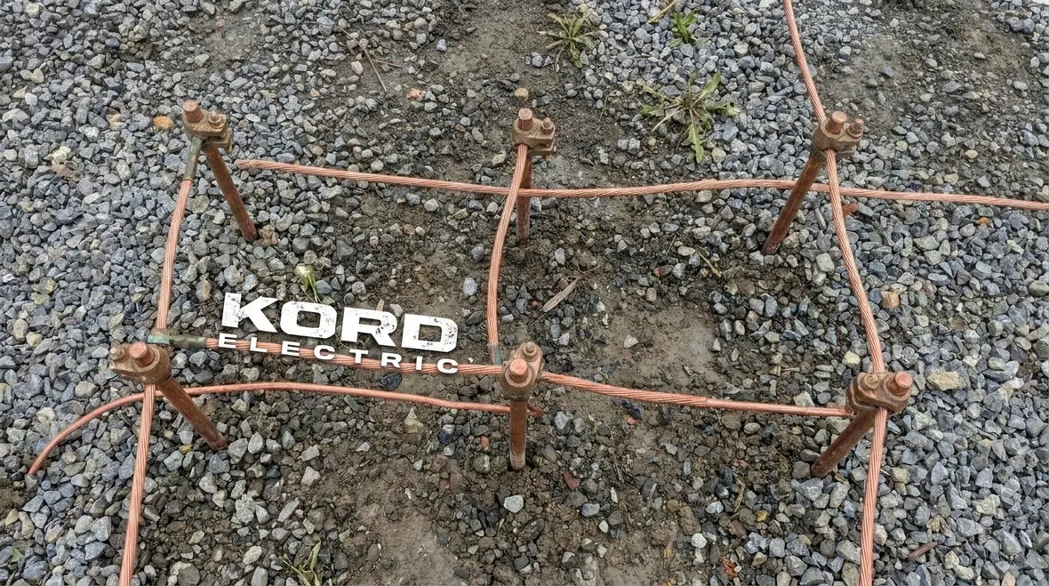 Technician reviewing NEC grounding electrode design above 2 kV