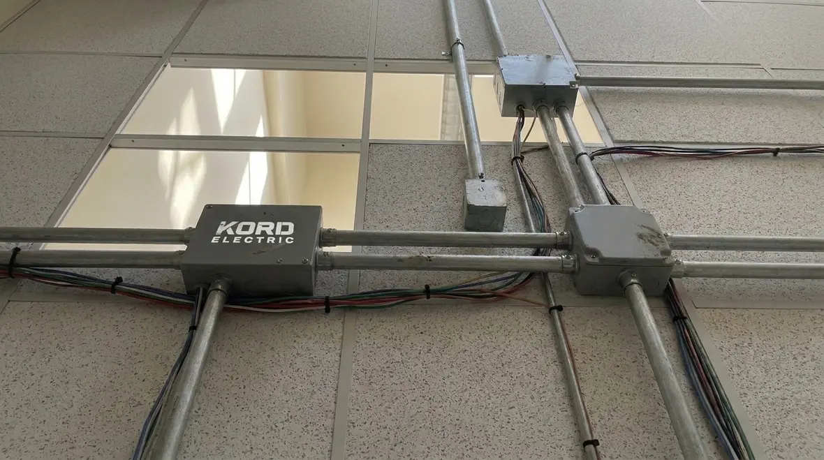 Technicians planning NEC 210.70 lighting outlet layout for 2026 projects