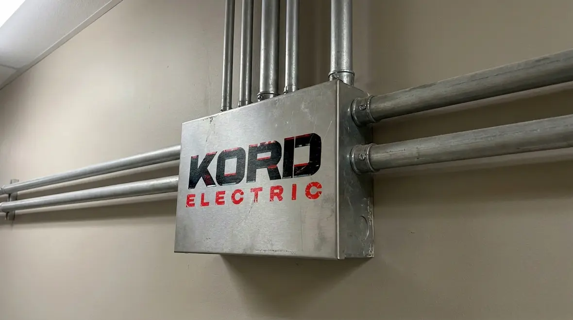 Electrician checking NEC metal boxes requirements in a commercial electrical room