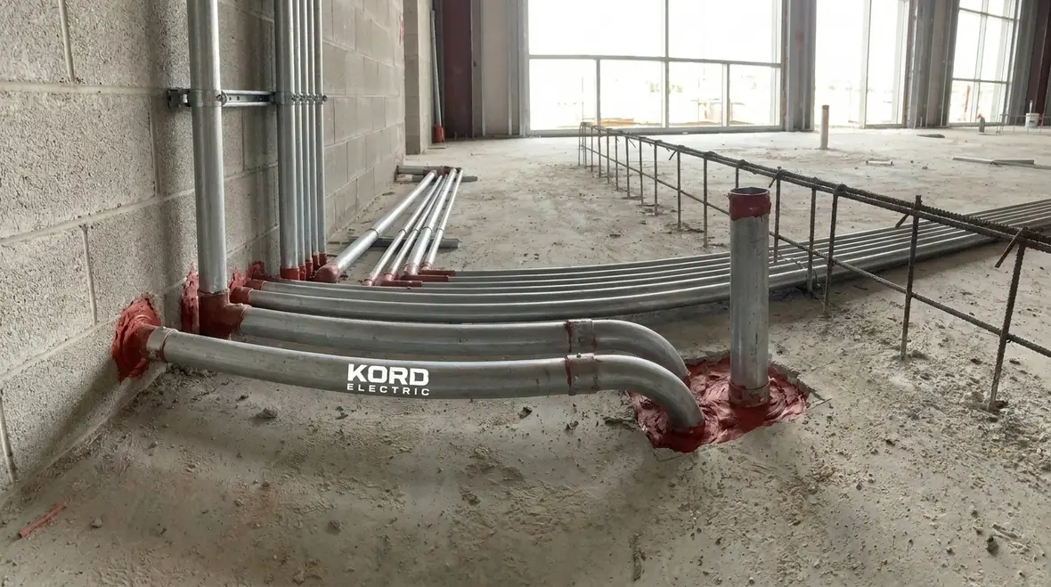 Close-up of a sealed NEC raceway at a wall penetration in an industrial facility