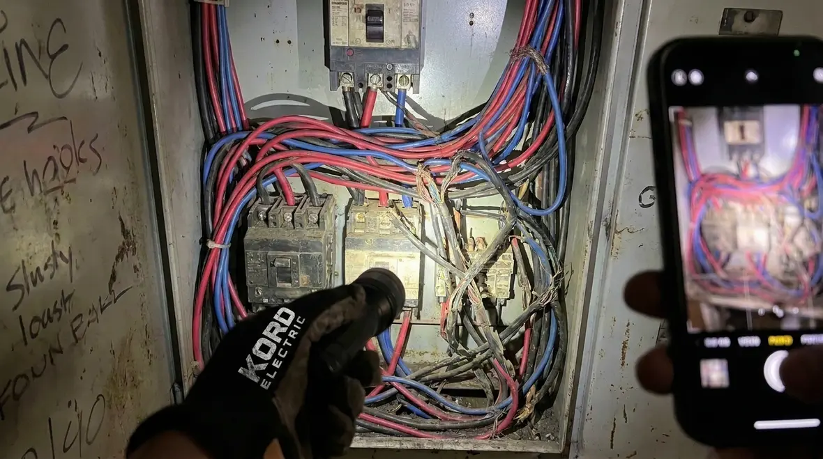 Technician verifying NEC side and back wiring clearances