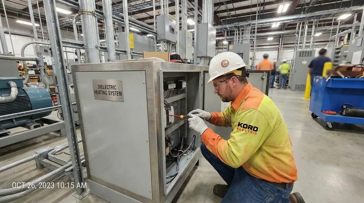 Technician reviewing NEC Section 665.19 dielectric heating interconnection details