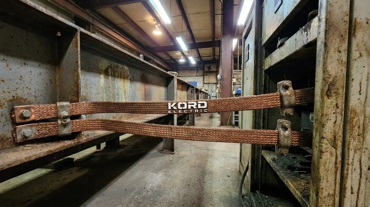 Technicians reviewing NEC Section 668.4 electroplating layout in a commercial facility