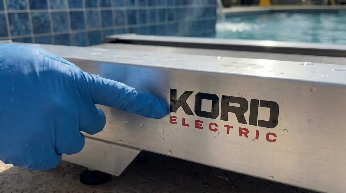 Technician reviewing aquatic exercise electrical nameplate for NEC 680.85 compliance