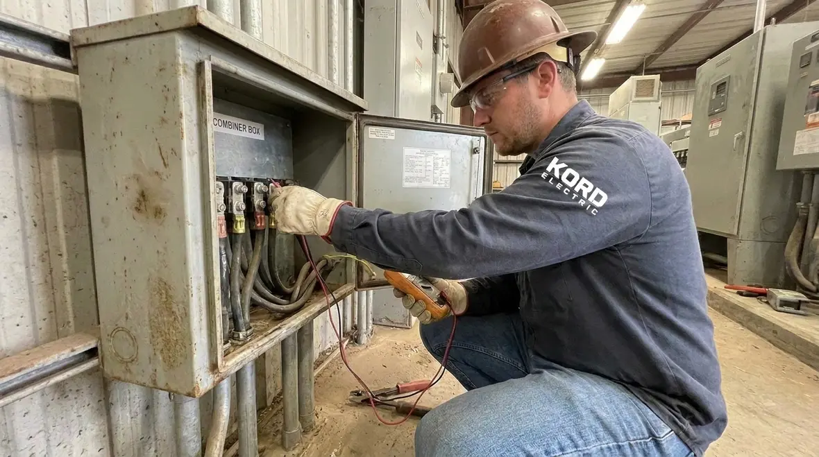 Electrician checking bonding and grounding connections on industrial PV equipment
